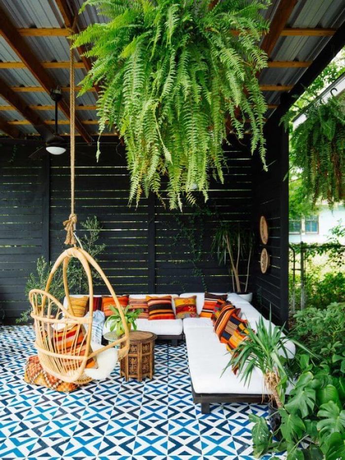 hanging plants, wooden swing, wooden sofa, white cushions, colourful throw pillows, pictures of screened in porches