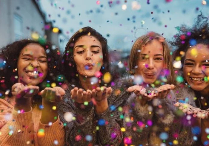four girls, blowing kisses, colourful confetti around them, party theme ideas