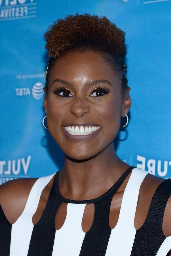 bob hairstyles for black women, issa rae smiling, black and white dress, blue background