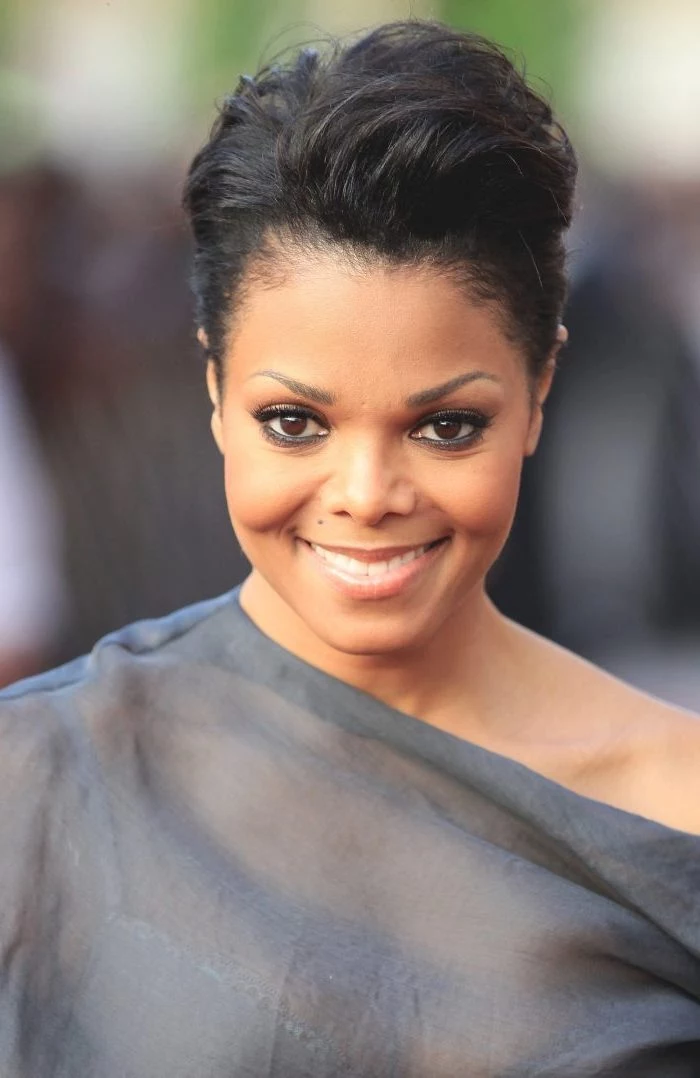 janet jackson smiling, wearing a grey dress, black hair, short curly hairstyles for black women