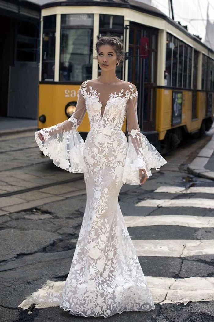 yellow tram, off shoulder, wide sleeves, long sleeve lace mermaid wedding dress, brown hair, in a low updo