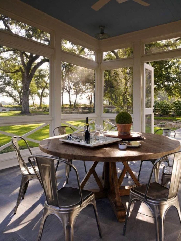 small front porch ideas, wooden table, metal chairs, screened in porch, tray with wine glasses