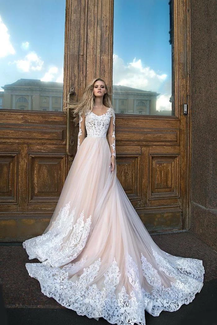 large wooden door, ivory dress, made of lace and chiffon, corset wedding dresses, long blonde wavy hair