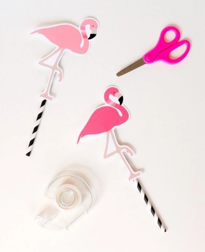 pink paper flamingos, on top of paper straws, diy crafts for teens, scotch tape, pink scissors