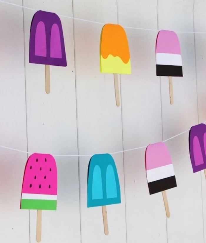 popsicle sticks, hanging garland, in different colours, diy crafts for teens, white wooden wall