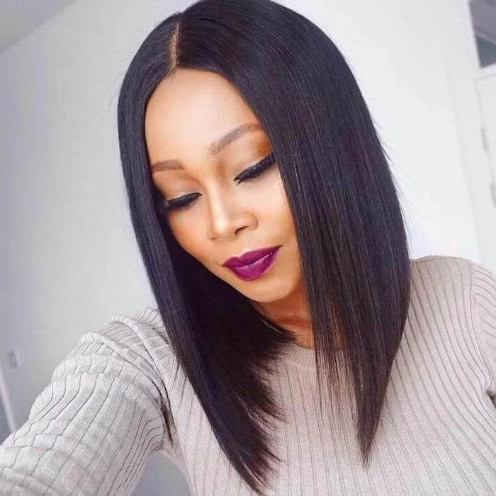bob haircuts for black women, asymmetrical black hair, grey sweater, purple lipstick