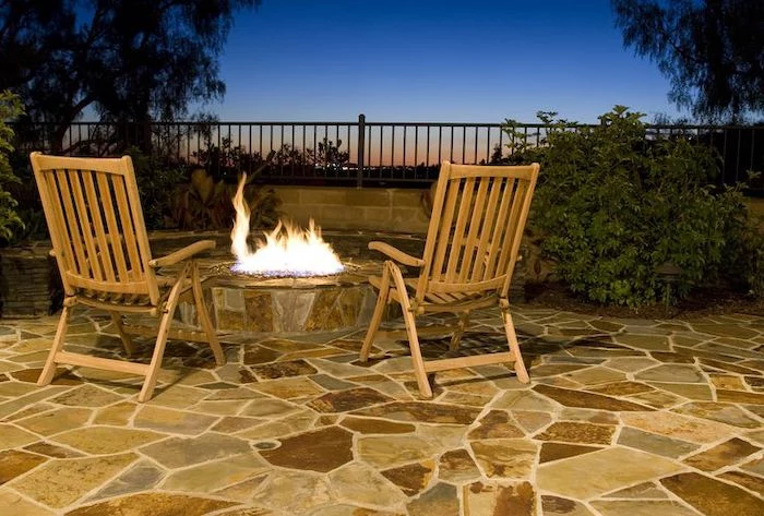 wooden armchairs, small round fire pit, small porch ideas, stone tiles floor, metal railing