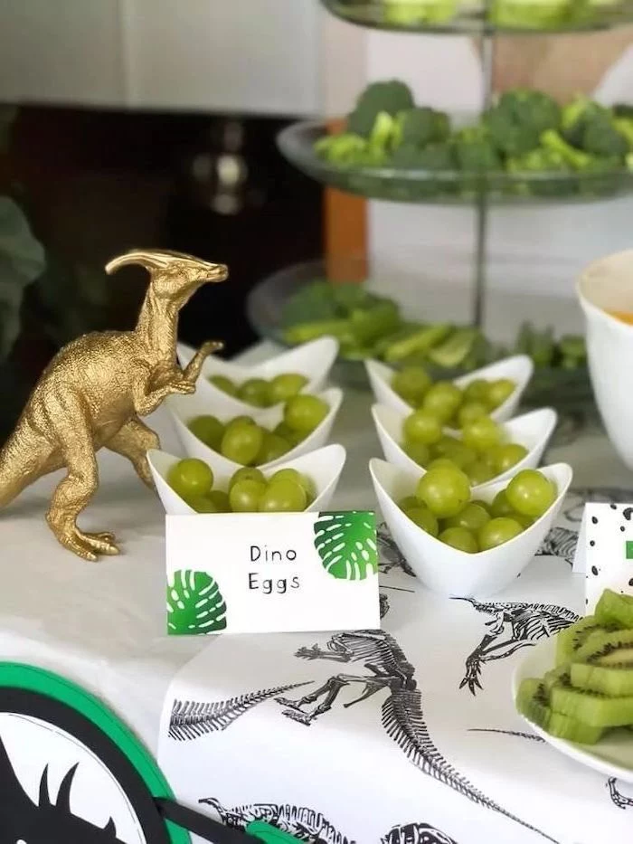 dino eggs, grapes in a white bowl, good places to have a birthday party, gold dinosaur figurine