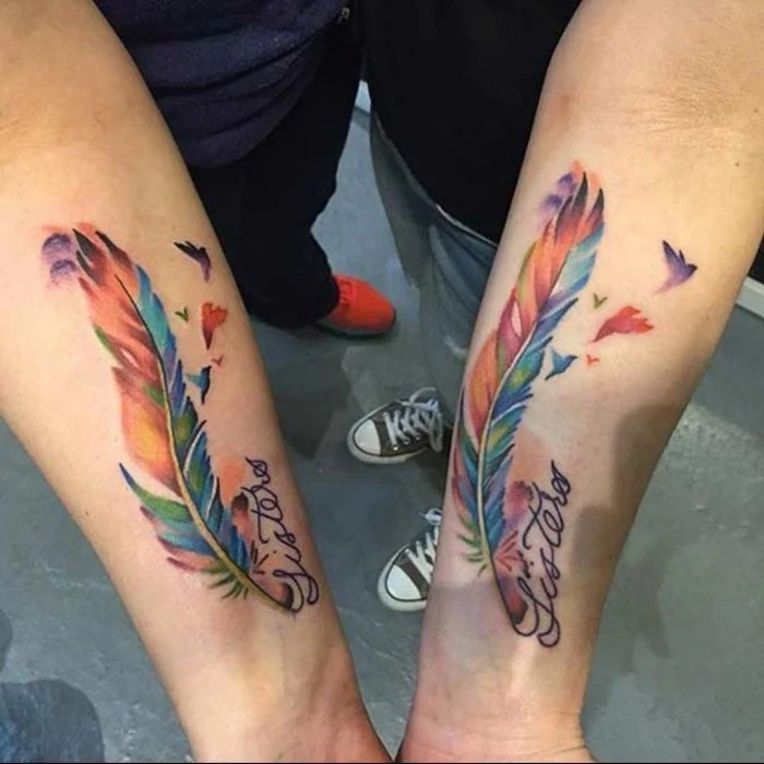 watercolour feathers, friendship symbol tattoos, forearm tattoos, grey cement floor