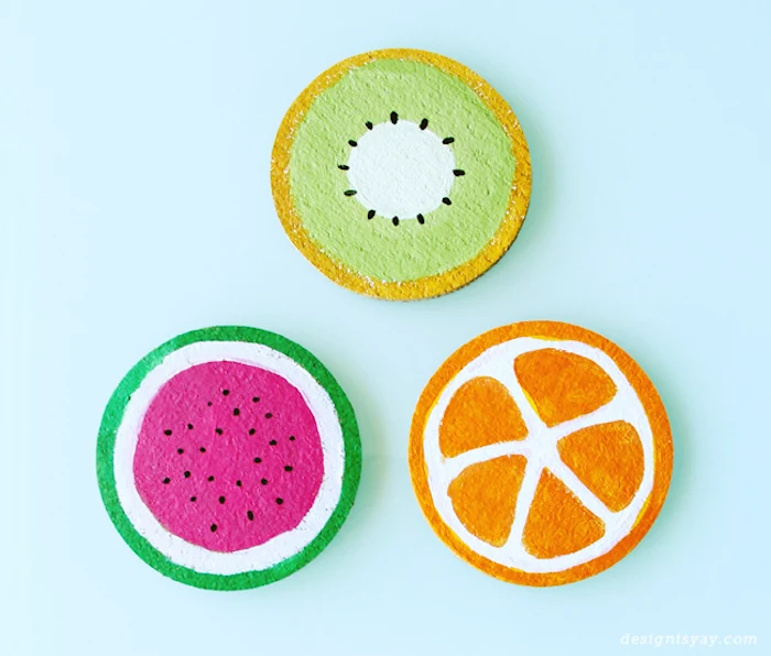 easy diys, wooden coasters, painted as fruits, kiwi orange and watermelon, blue background