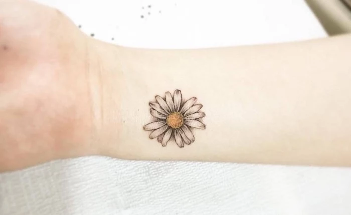coloured daisy, wrist tattoo, small hip tattoos, white paper