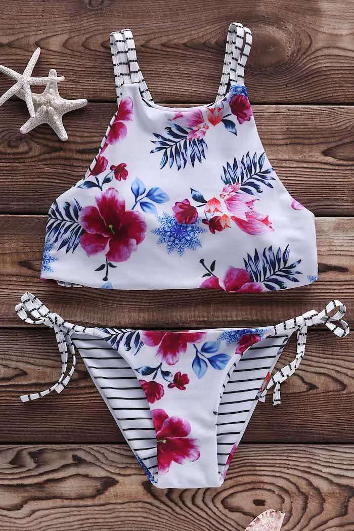 big girl swimsuits, white floral print, black and white striped straps, wooden background