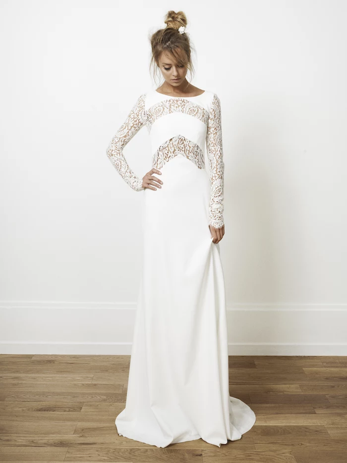 chiffon wedding dress, with lace sleeves, blonde hair, in a messy bun, wooden floor, white wall