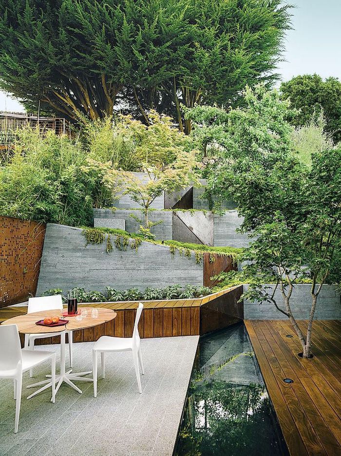 front porch pictures, levelled greenery, flower beds, white metal chairs, wooden table, tall trees