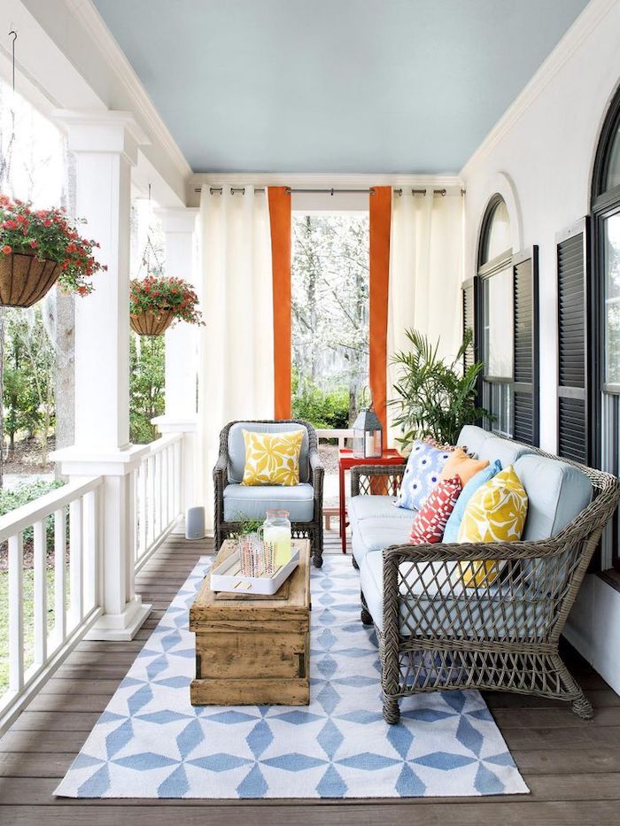 wooden garden furniture, blue cushions, front porch decor, colourful throw pillows, blue and white rug, vintage table