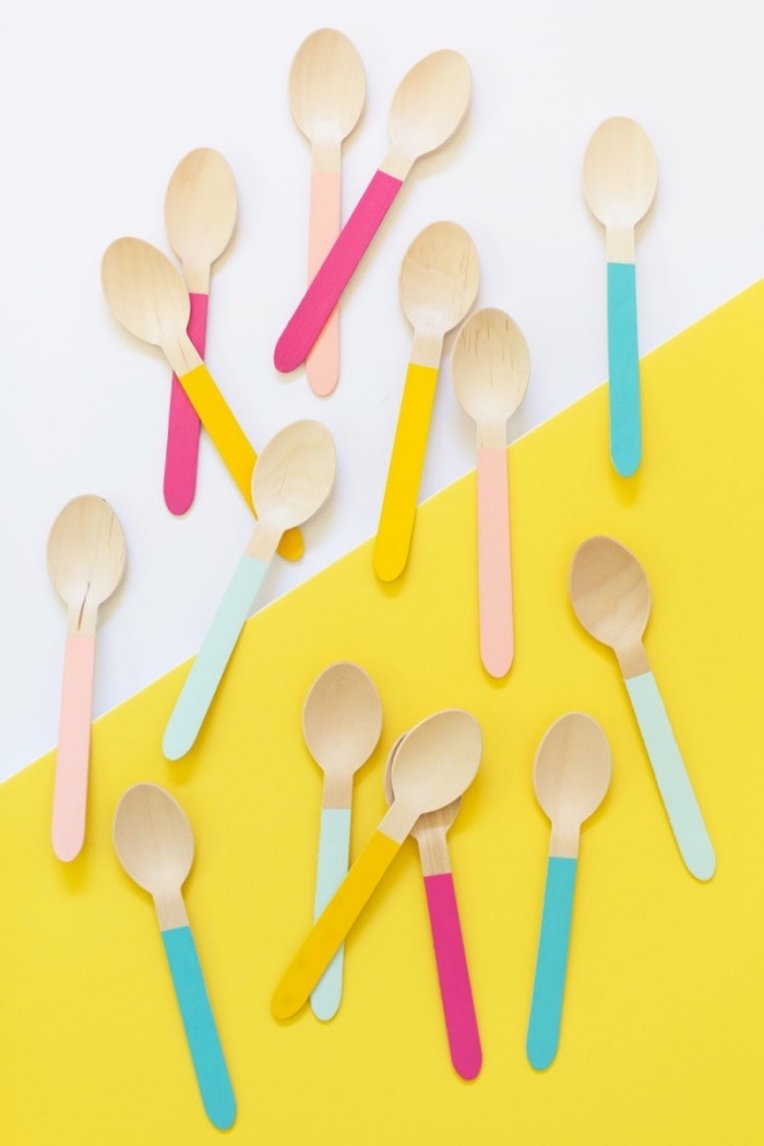wooden spoons, painted in blue and pink, yellow and white background, diy crafts for adults
