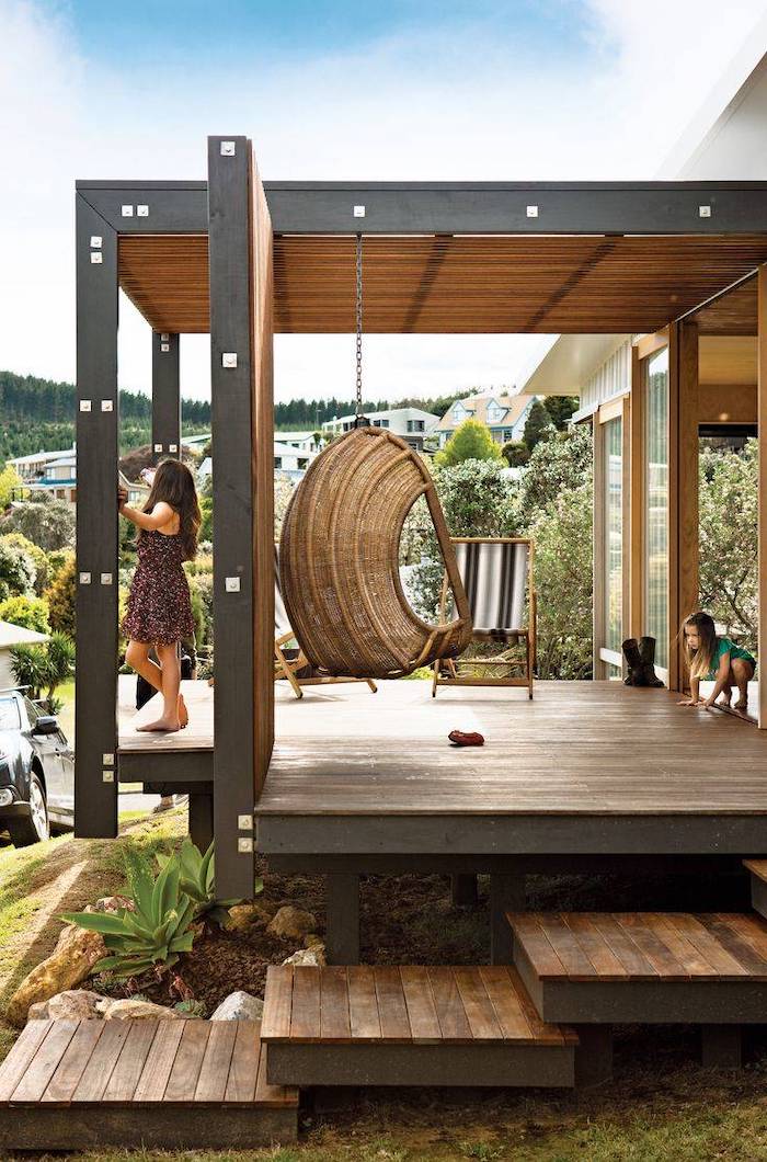 wooden swing, black and grey wooden chair, front porch decor, wooden staircase, child and a woman