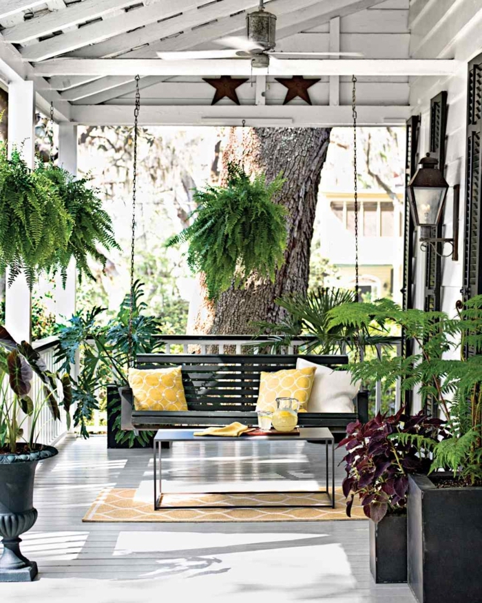 pictures of screened in porches, wooden swing, held by metal chains, yellow throw pillows, yellow rug