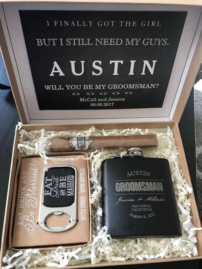 carton box, metal flask, bottle opener, wrapped cigar, groomsmen gifts