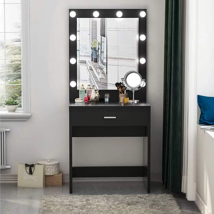 black makeup vanity, mirror with lights, small round mirror, white wall, grey floor, grey carpet