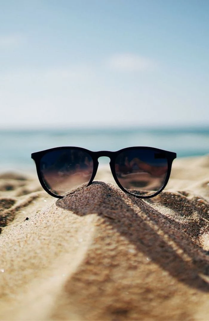 black sunglasses, in the beach sand, cute backgrounds, blue sky