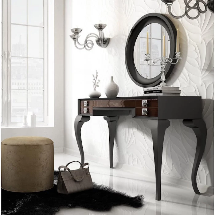 white wall, black wooden, makeup vanity, gold ottoman, black rug, round mirror