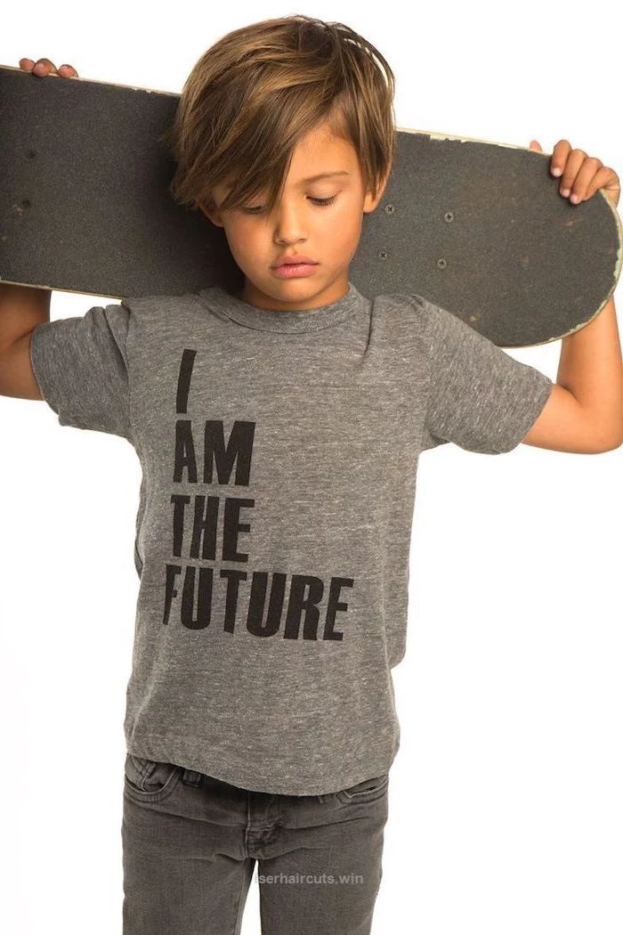 little boy, carrying a skateboard, i am the future t shirt, boys haircuts, blonde hair, dark jeans