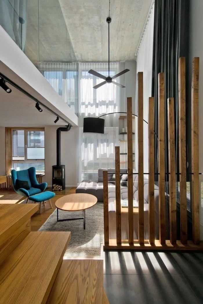 wooden sticks, room divider ideas, blue armchair, grey corner sofa, wooden staircase, white rug