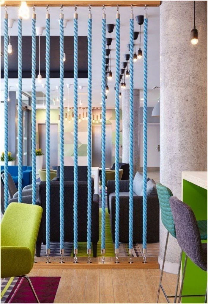 blue ropes, green armchair, wooden floor, sliding room dividers, grey and blue bar stools, grey sofas