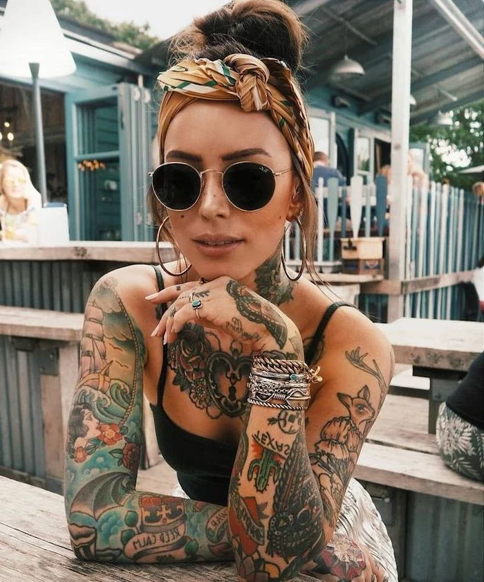 woman with sunglasses, coloured tattoos, on both hands, arm tattoo ideas, silver bracelets, chest tattoo