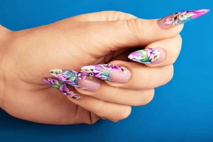 long stiletto nails, spring nail designs, blue background, floral motifs, pink flowers