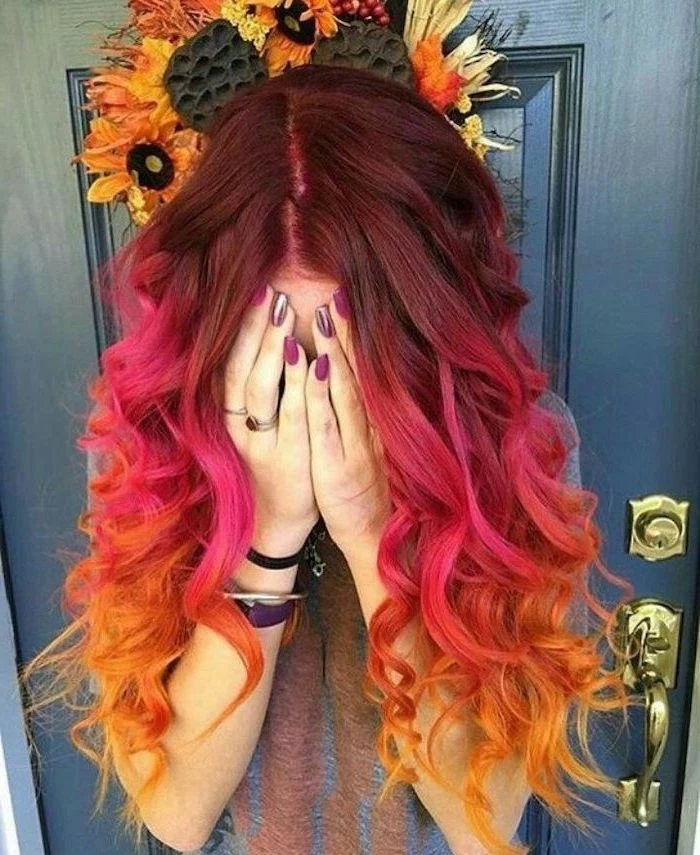 dark red, to pink and yellow, long curly hair, caramel ombre, purple nail polish