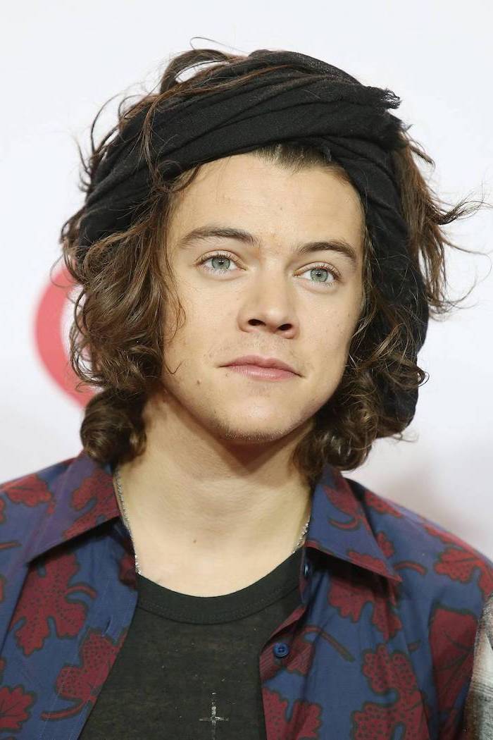 cool haircuts for boys, harry styles, long brown, curly hair, black bandana, red and blue shirt, green eyes
