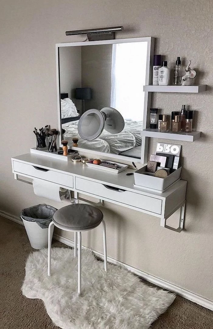 white floating shelf, with drawers, white metal stool, mirrored vanity table, white wall, white rug