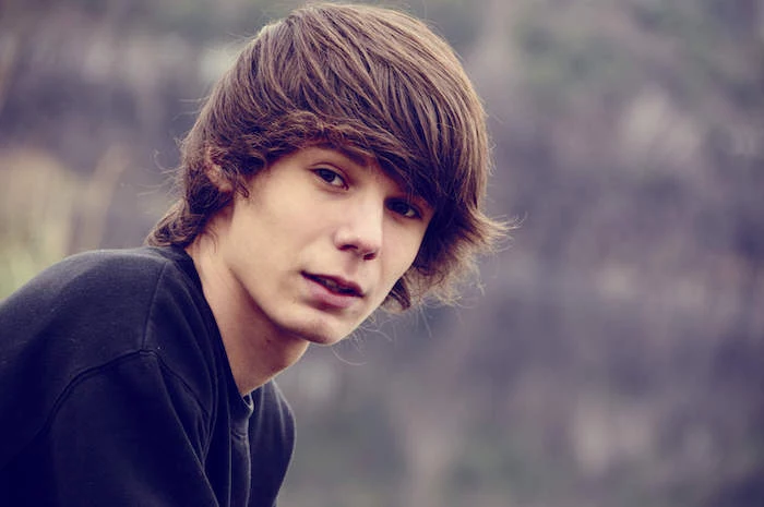 long hairstyles for boys, black blouse, brown hair, blurred background
