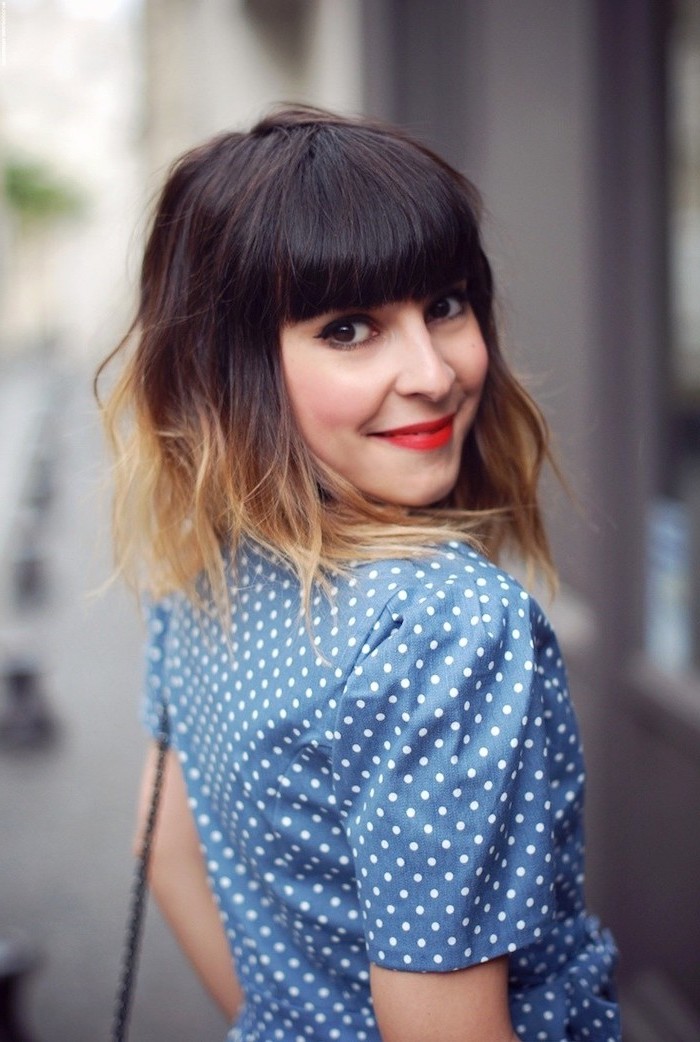 short bob hairstyle, with bangs, dark brown to blonde, dark ombre hair, blue dress, with white dots on it