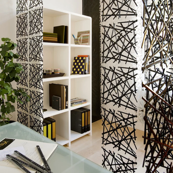 black metal sticks, arranged together in square blocks, room divider shelves, white bookcase, glass desk