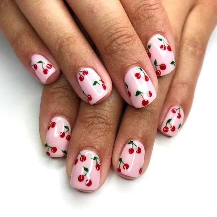 nail designs for short nails, pink nail polish, red cherries, white background