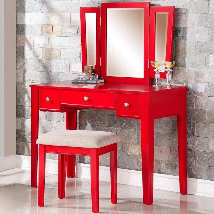 corner makeup vanity, red wooden table, red wooden stool, three fold mirror, stone wall