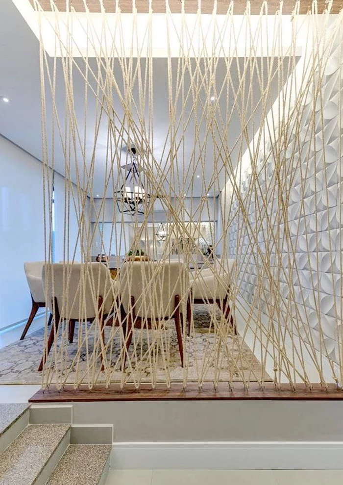 white ropes, white chairs, room divider bookcase, white wall, dining table