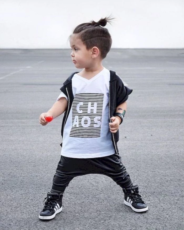 little boy, short guy haircuts, brown hair, in a bun, black leather pants, white shirt, black vest, black sneakers
