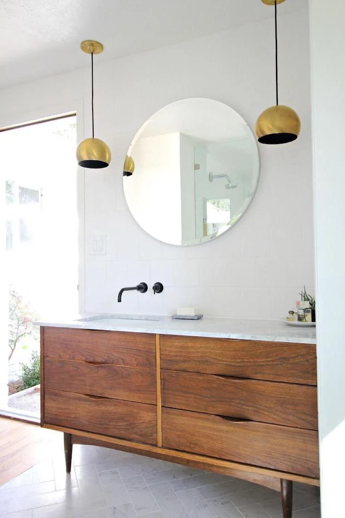 round mirror, white makeup vanity, wooden table with sink, marble countertop, white wall