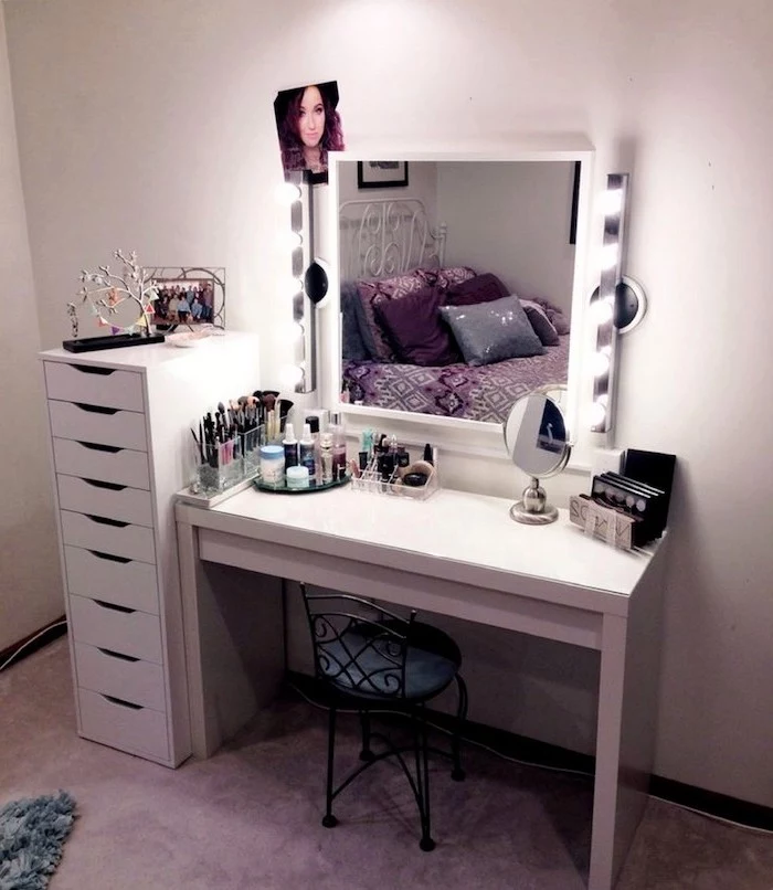 white drawers, black metal chair, bathroom makeup vanity, mirror with lights, white wall