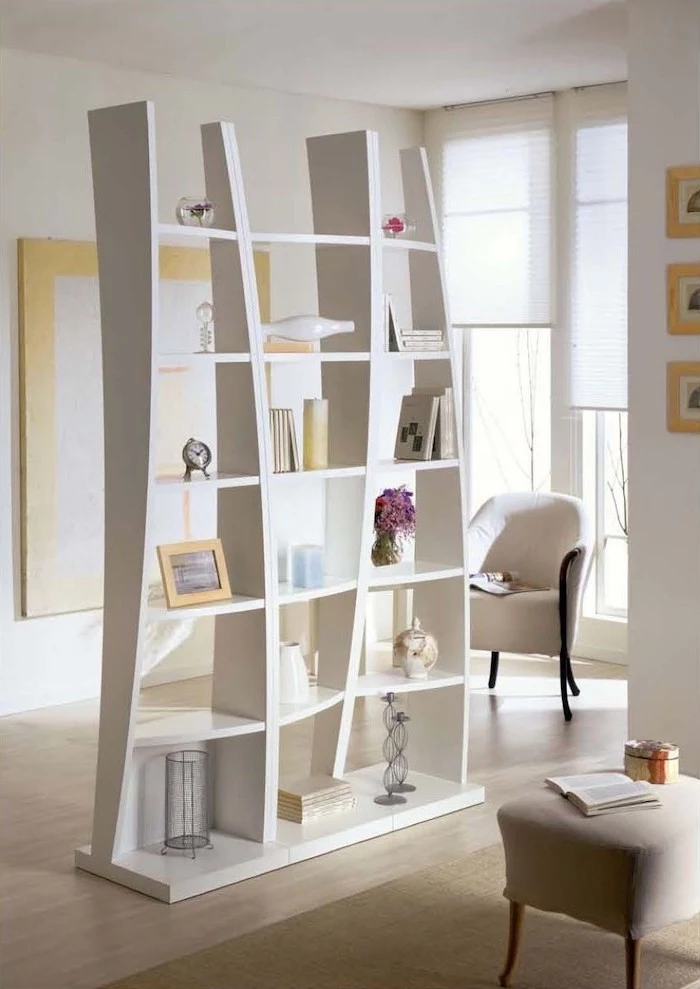 white bookcase, wooden floor, white armchair, white ottoman, folding screen room divider