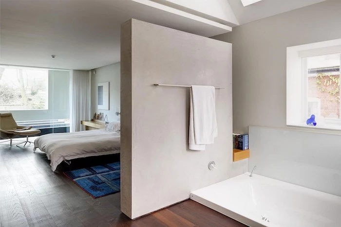 wooden floor, sinking bathtub, indoor privacy screen, separating bedroom and bathroom