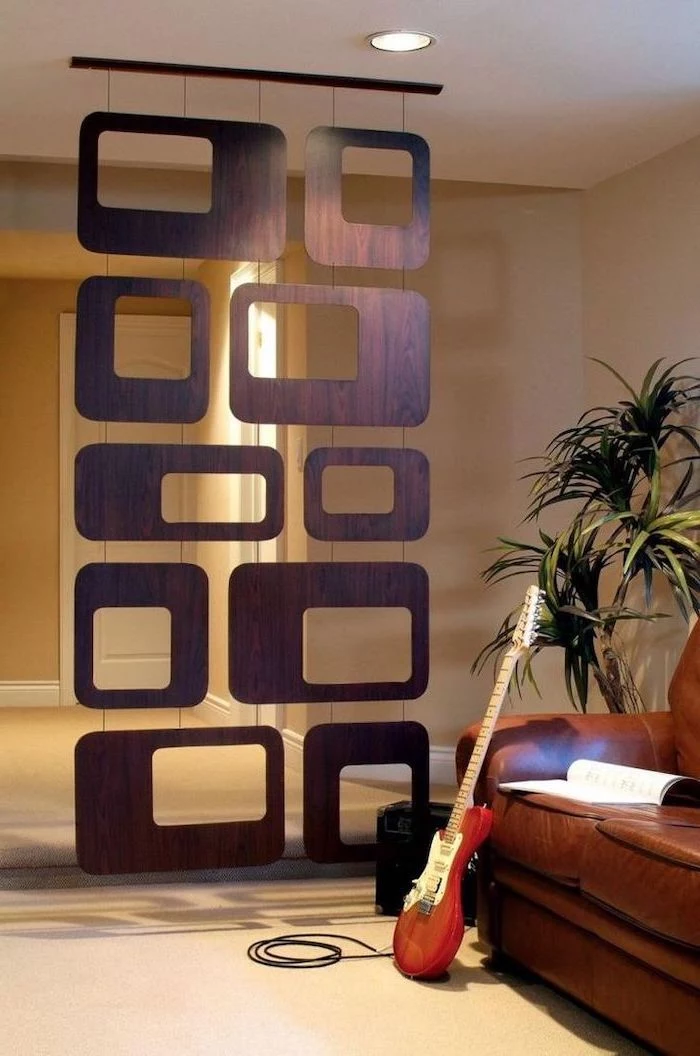 geometrical wooden blocks, arranged together, portable room dividers, electric guitar, brown leather sofa