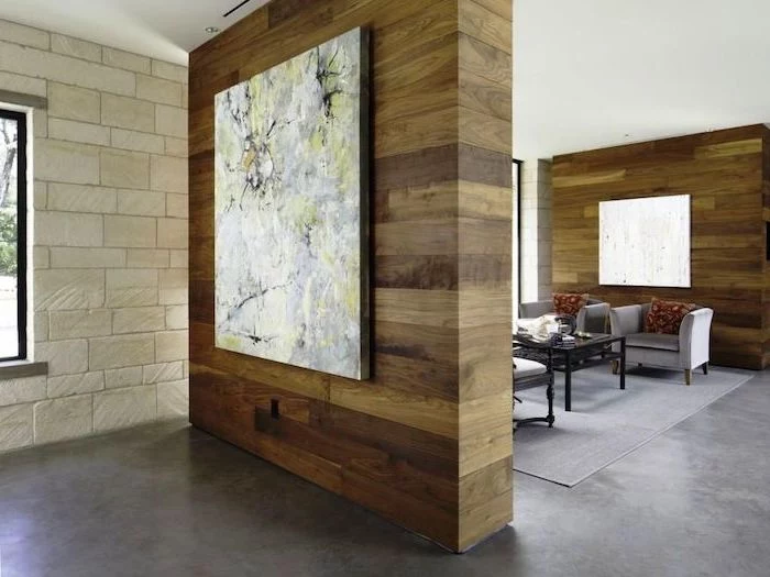 decorative room dividers, made of wood, abstract art, stone wall, cement floor, grey armchairs