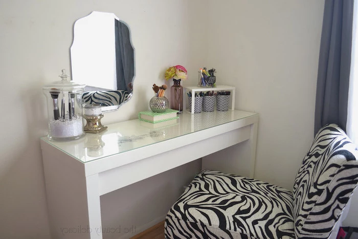 zebra printed chair, white table, small mirror, makeup brushes, dressing table with drawers