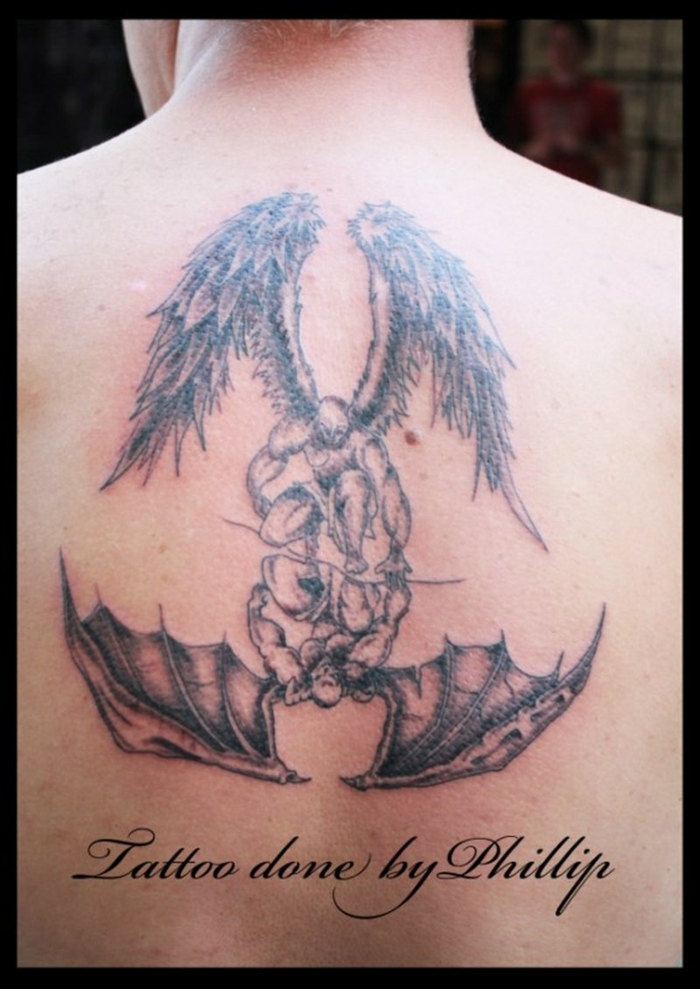 back tattoo of a mirrored image of angel and demon, angel wing and demon wing tattoo, back tattoo