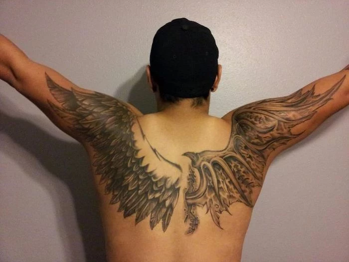 wings chest tattoo, man with black hair, one angel wing, one devil wing, white background